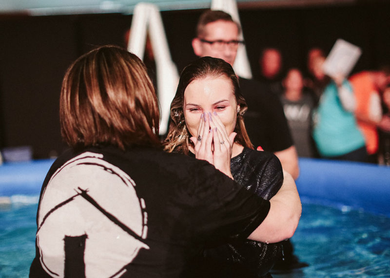 a happy, young woman emerging from a baptism